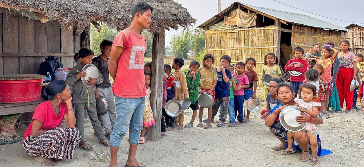 Children from the marginalized Chepang village of Devendapur, Chitwan, patiently queuing with their food bowls for a rare community feast provided by One Golden Angel.